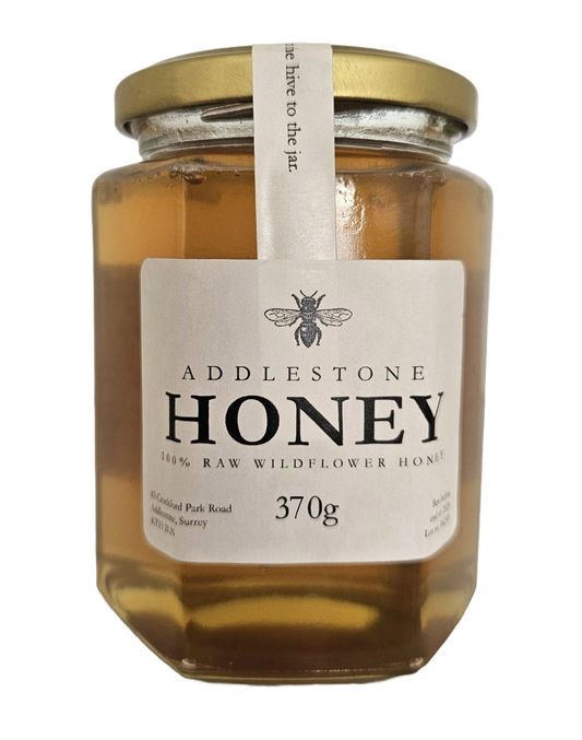 Jar of Addlestone Runny Honey with a gold lid on a white background