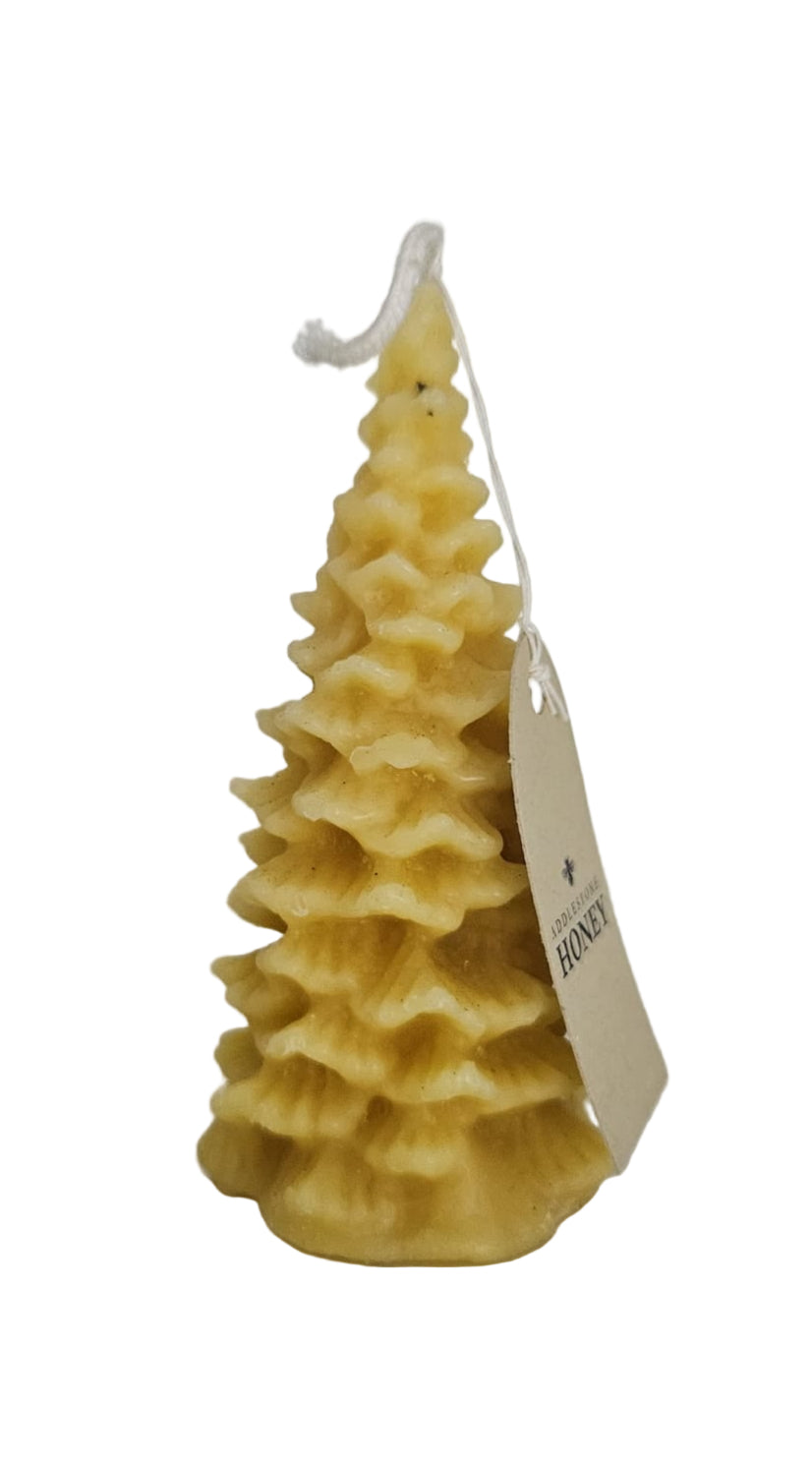 Beeswax candle shaped like a Christmas tree with a tag on a white background