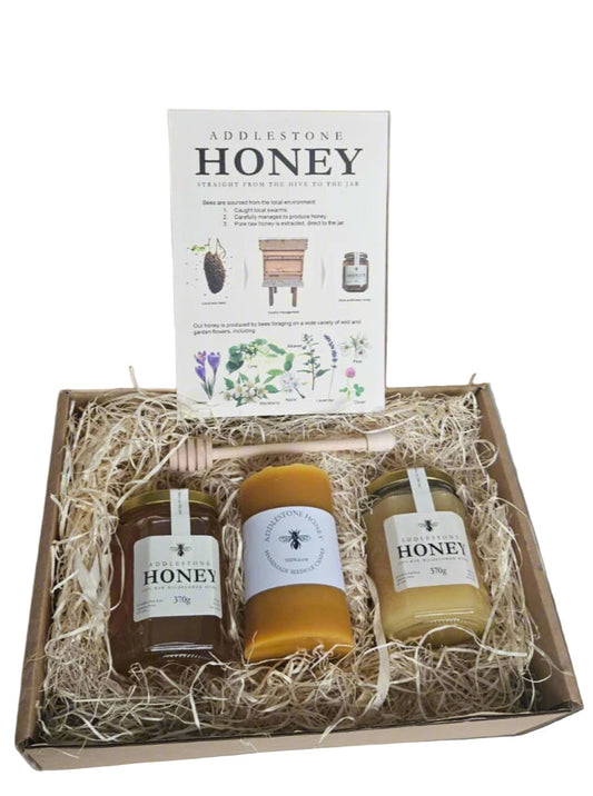 Box of Addlestone Honey with 2 jars of honey and a beeswax candle and honey dipper.