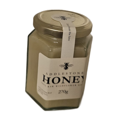 A glass jar of Addlestone Creamed Honey with a gold lid and a white label, shown on a plain white background.