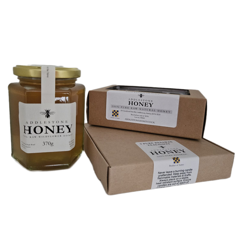 A jar of Addlestone Honey with a box of cut comb and a box of pure beeswax tealights, all on a plain white background.