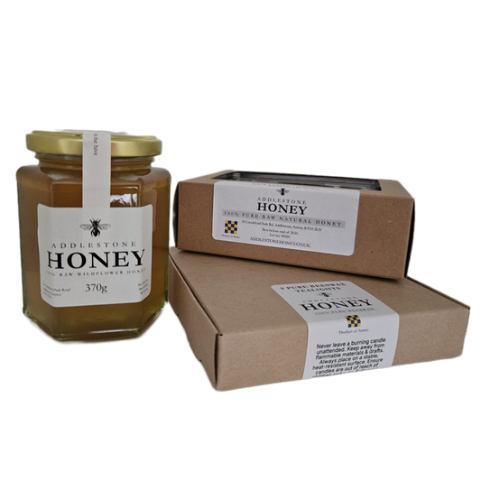 A jar of Addlestone Honey with a box of cut comb and a box of pure beeswax tealights, all on a plain white background.