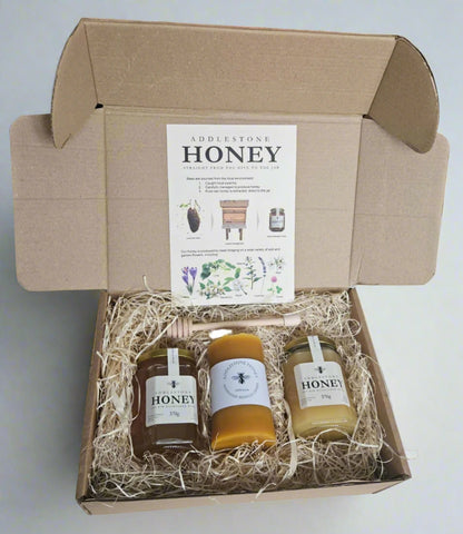 Honey gift box with two jars and a candle in a cardboard gift box.