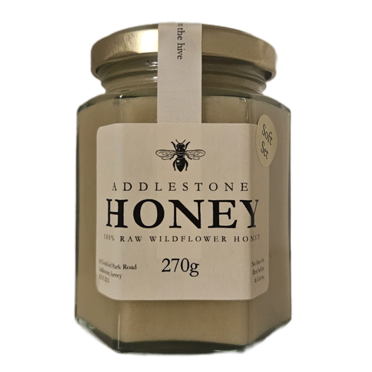 A jar of Adlestone Honey Raw Wildflower Honey, 270g, with a gold lid and a cream-colored label featuring a bee logo.